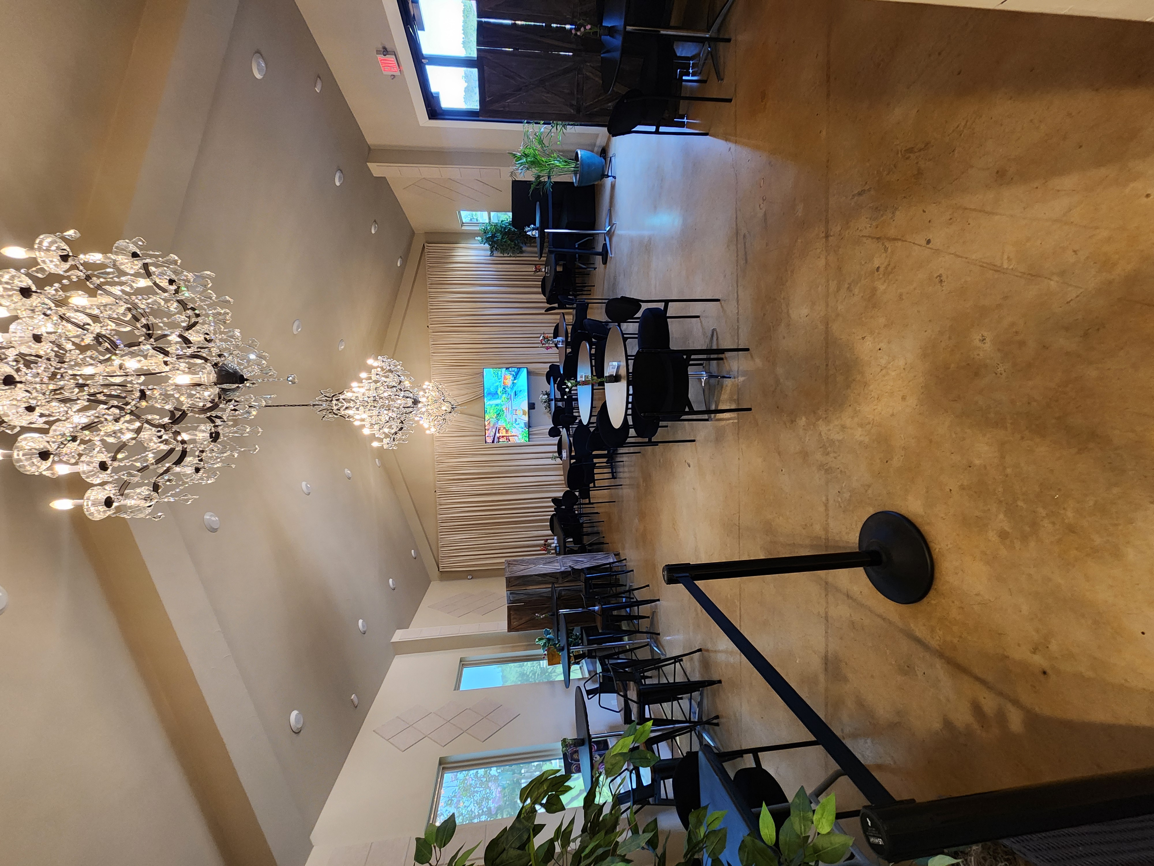 Kai-Simone Winery event room with crystal chandeliers, black tables and chairs